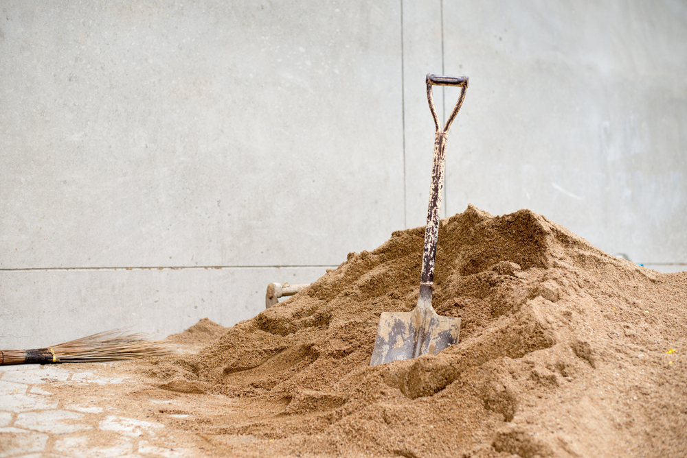 一堆洗过的沙子，上面立着一把铲子